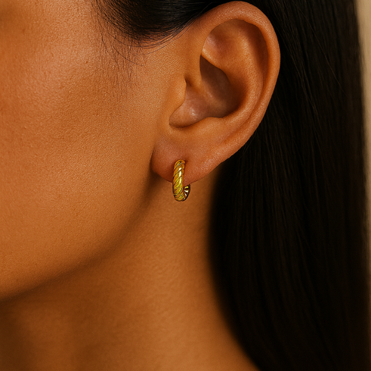 gold huggie earrings on model